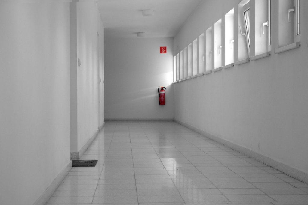 Fire extinguisher mounted in a clean communal corridor, illustrating the type of equipment included when considering fire extinguisher inspection costs and routine fire safety maintenance.